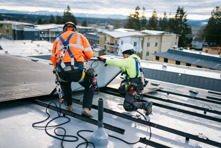 men installing solar panels on roof