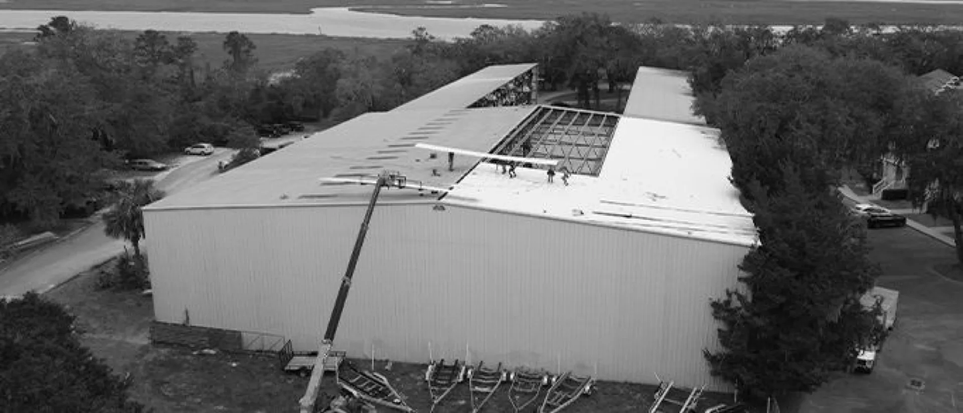 Aerial of a coastal Georgia commercial building during a metal re-roof beside the marsh