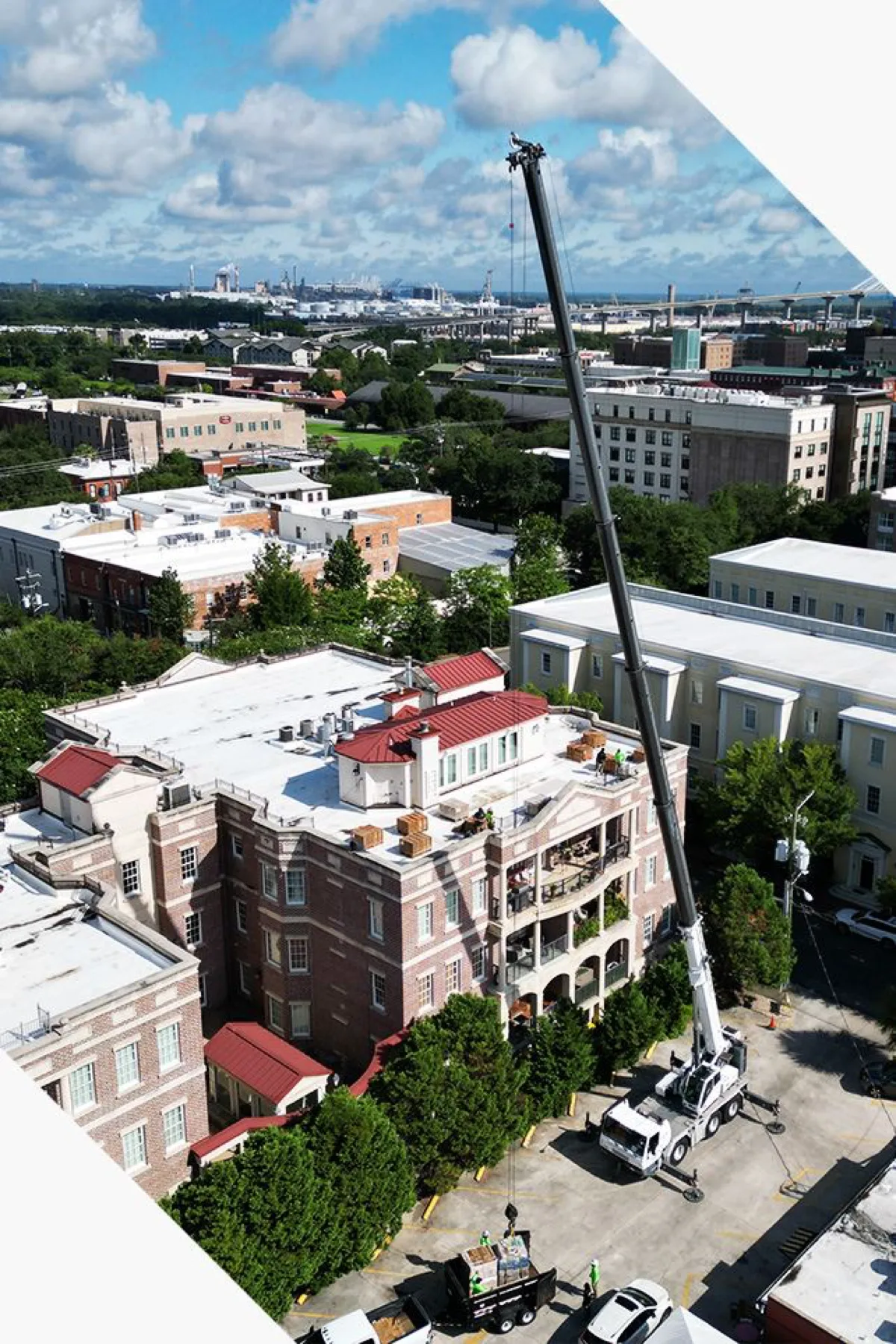 A crane working over a historic downtown Savannah building during a roofing project