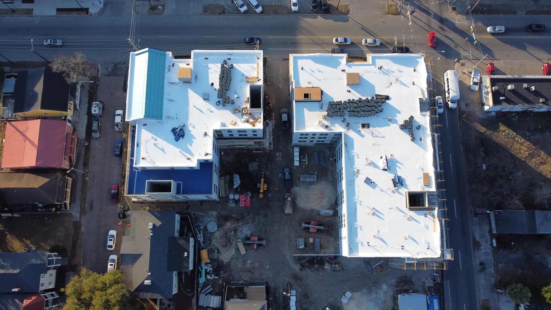 Twin commercial buildings with white TPO roofs, aerial view