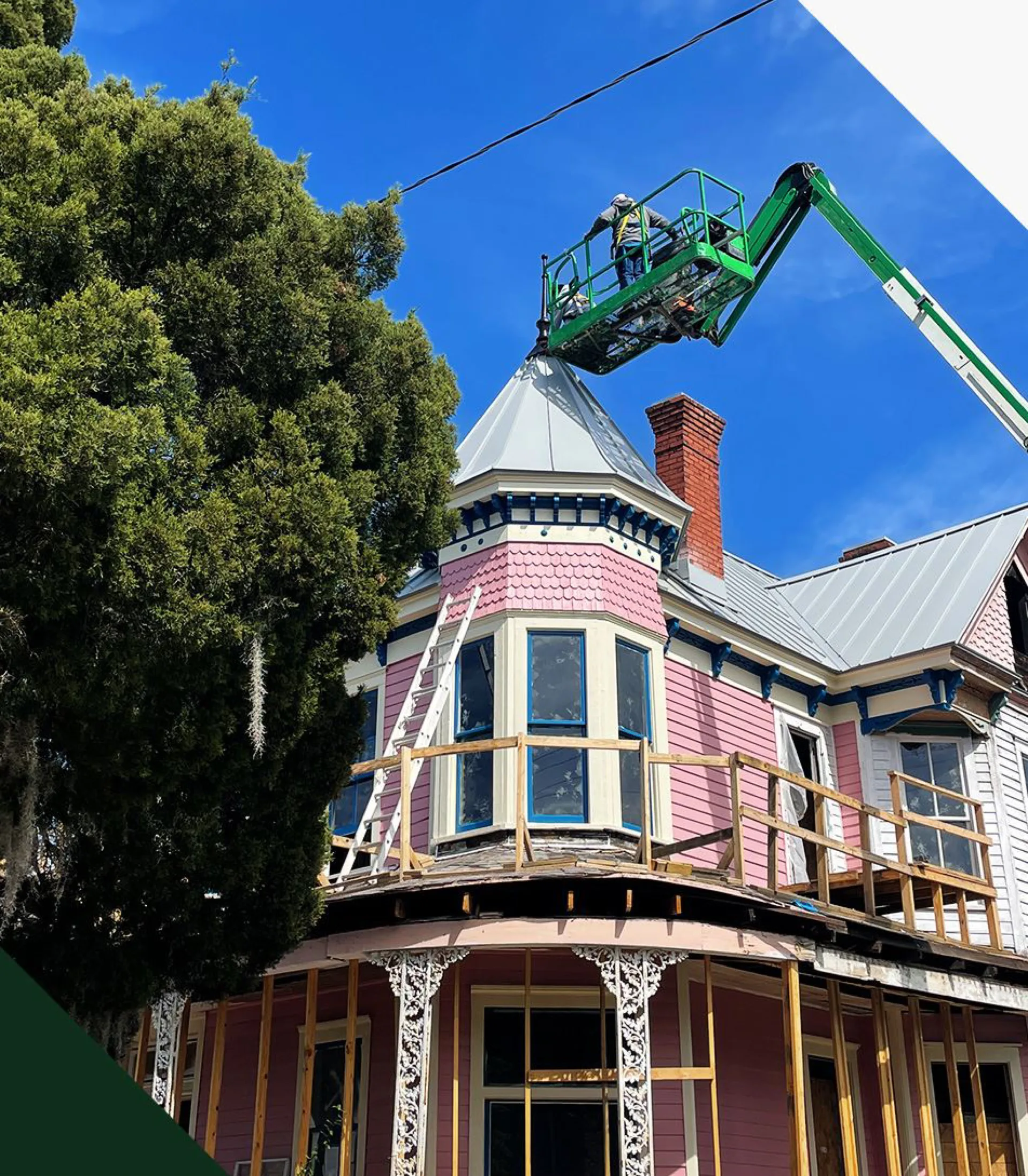 A historic Savannah Victorian under roof restoration, with a lift reaching the turret
